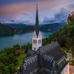 Wall Mural - Bled, Slovenia - Aerial panoramic view of the beautiful St. Martin's Parish Church at blue hour with Bled Castle (Blejski Grad) and Julian Alps at the background with amazing clouds and sky
