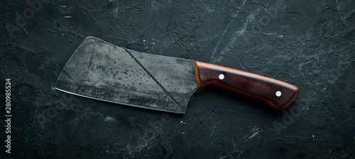 Fotografía Kitchen old knife on a black stone table