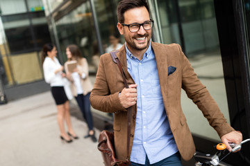 Young businessman riding on his bicycle. Going everywhere by his bike