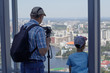 © IrinaK - A boy and his grandfather watching from a panoramic window of a high-rise building on the city of Yekaterinburg