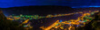 Montenegro, XXL panorama of illuminated houses, streets, harbor and old town of city of kotor bay at night from above surrounded by majestic mountains and waterside