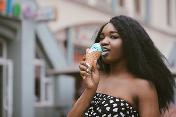 Wall Mural - Positive young girl holds delicious cold ice cream, looks with eyes full of happiness, enjoy spare time, has professional make up.