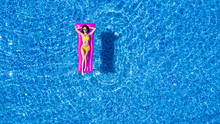 Slim Young Woman Lying On Air Mattress In The Pool. Top View.