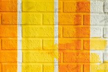 Bricks Surface Of Wall, Painted Striped In Bright Orange And Yellow Colors. Graphic Texture Of Colorful Wall, For Background