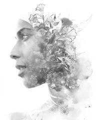 Double exposure. Paintography. Close up profile portrait of an attractive woman with strong ethnic features combined with unusual hand made drawings with floral and plant motifs, black and white