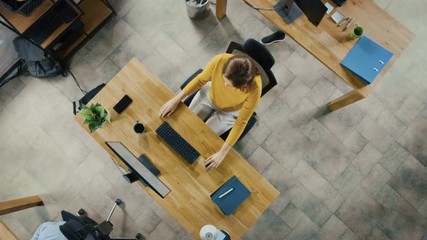 Canvas Print - Beautiful Young Female Specialist Sitting at Her Desk Working on Desktop Computer. Diverse and Modern Office with Professionals Doing their Jobs. Top View Crane Camera Shot Moving into Portrait