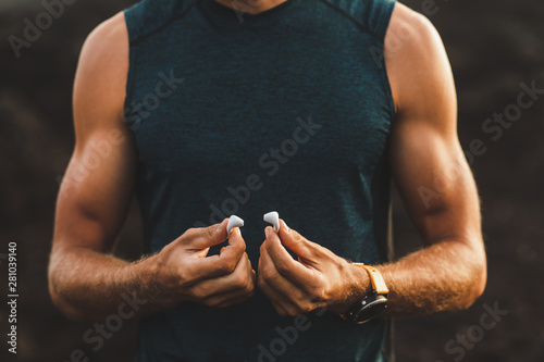 Fotografía Man holding air pods headphones in hands close-up