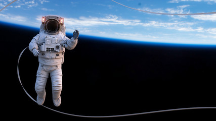 Wall Mural - astronaut with safety tether performing a spacewalk in empty space