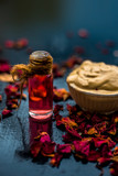 Fototapeta Kwiaty - Ubtan/face mask/face pack of Multani mitti or fuller's earth on wooden surface in a glass bowl consisting of Multani mitti and rose water for the remedy or treatment of oily skin.On wooden surface.