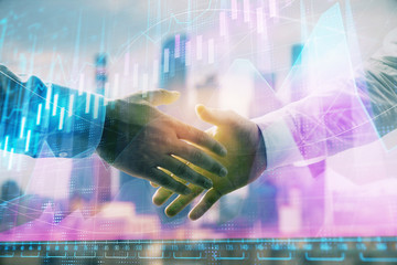 Double exposure of financial graph on cityscape background with two businessman handshake. Concept of stock market deal