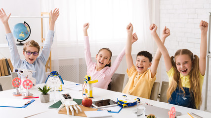 Poster - Happy children with raised hands after robotics class
