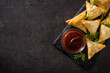 Samsa or samosas with meat and vegetables on black background. Traditional Indian food. Top view. Copyspace