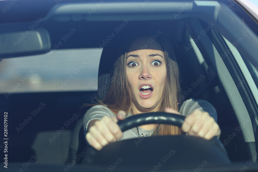 Scared driver driving a car before an accident - obrazy, fototapety, plakaty 