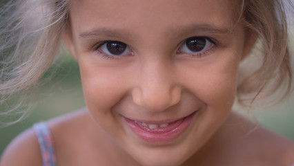 Wall Mural - Authentic shot of cute little girl with is smiling outside her house on a sunny day.