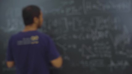 Wall Mural - Male teacher writing on blackboard and pointing at the student who raising hand up for asking in the classroom at school