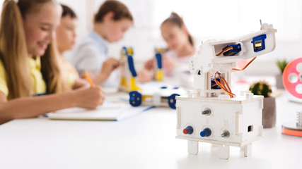 Wall Mural - Children studying in class with robot at foreground