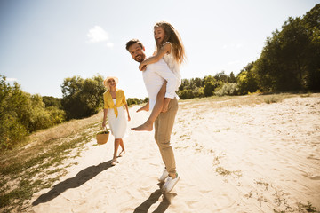 Happy father playing with daughter and piggybacking her