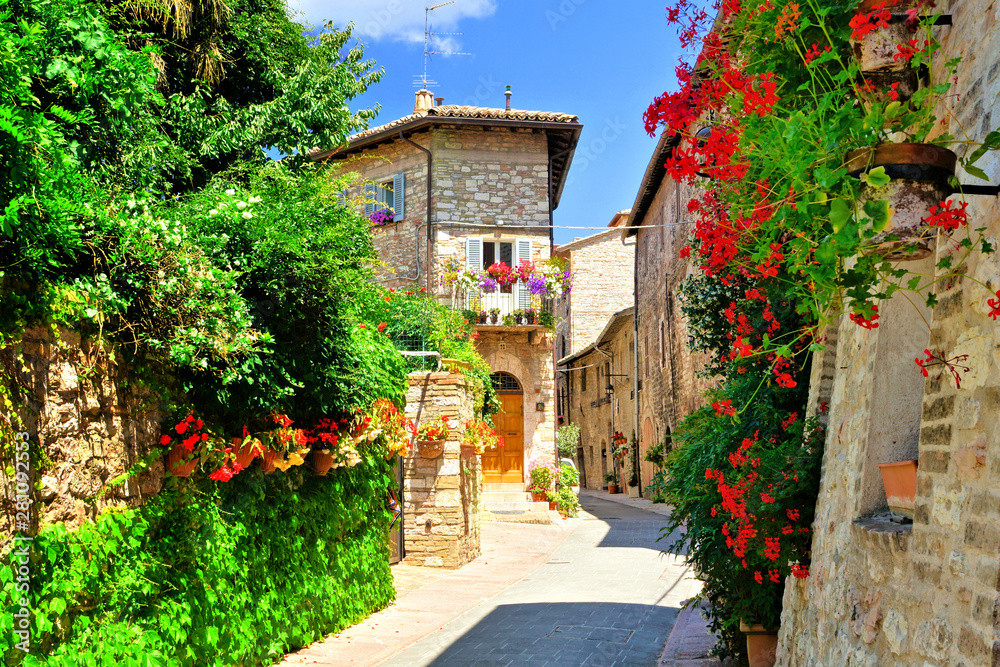 Flower filled medieval street in the beautiful old town of Assisi, Italy - obrazy, fototapety, plakaty 