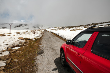 red car moving on the highway. on the roadside is snow