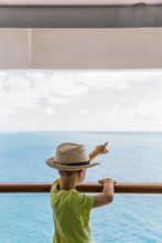 Young Boy Pointing To Land From Cruise Ship As They Arrive In Port