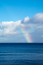 Rainbow And Clouds Over The Ocean