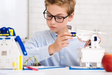 Poster - Schoolboy constructing electronic robot at stem lab