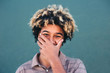© Lucas Ottone/Stocksy - Shy afro teenager laughing