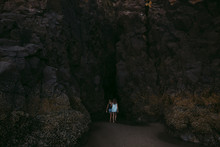 Sisters Exploring A Cave Togther At The Beach.