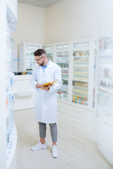 Wall Mural - Serious stylish pharmacist looking for necessary medicine