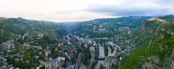 Wall Mural - Old rusty and functioning ropeway or cable car cabins in Chiatura. Panorama of the city district and apartment buildings on the rock and Mine at Ropeway station Rgani.