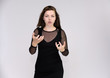 © Вячеслав Чичаев - Portrait on white background of a pretty slim beautiful fashionable adult girl with beautiful brunette hair in a black dress. Standing talking demonstrating different poses and emotions