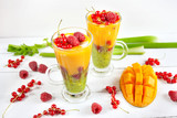 Fototapeta Kuchnia - A multi-layered smoothie with mango, kiwi, celery, currants and raspberries