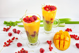 Fototapeta Kuchnia - A multi-layered smoothie with mango, kiwi, celery, currants and raspberries