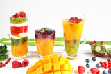 Fototapeta Kuchnia - Multilayered smoothie with yellow, green and red fruits and vegetables