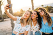 © ManuPadilla - Group of three women friends making a selfie in a beach during a summer day. Friendship and holiday.