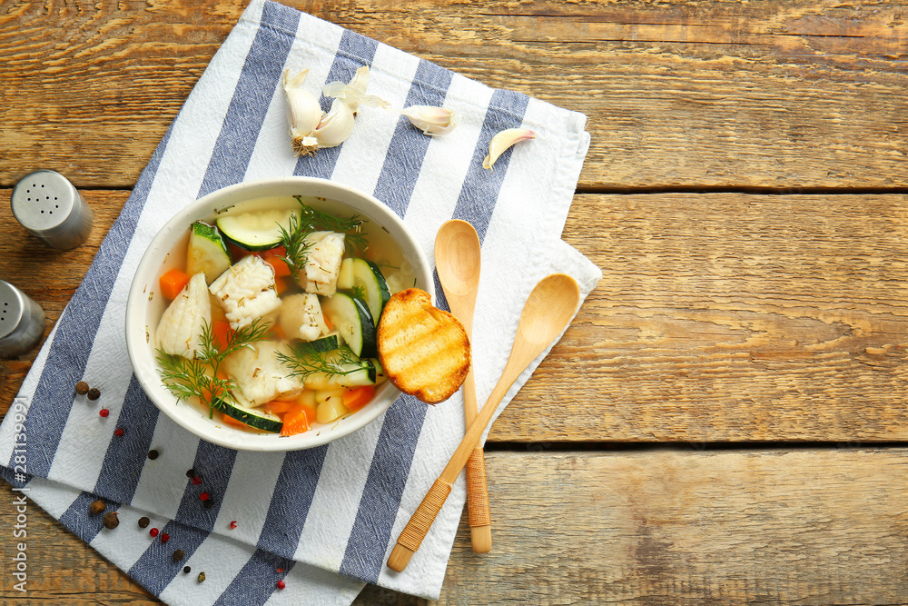 Bowl of tasty soup on wooden table