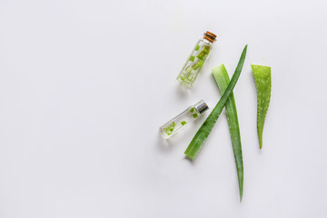 Fresh aloe leaves with essential oil on white background