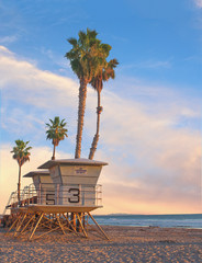 Life guard tower –  Life guard tower with palm trees at sunset in California    