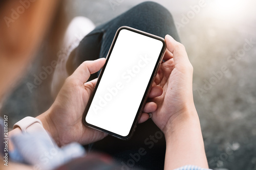 Fotografía Top view Woman sitting and holding blank screen mock up mobile phone