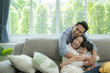 © saksit - happy asian family spending time together on sofa in living room. family and home concept