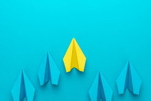 Flat Lay Image Of Business Competition Concept. Leadership Concept With Paper Planes Over Turquoise Blue Background With Copy Space. Top View Of Yellow Plane Leading Blue Ones.
