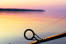 Fishing Rod Spinning Ring With The Line Close-up. Fishing Rod Over The Crystal Still Water. Fishing Rod Rings. Fishing Tackle. Fishing Spinning Reel. Soft Lighting