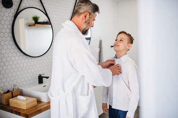 Wall Mural - Mature father with small son getting dressed in the bathroom in the morning.