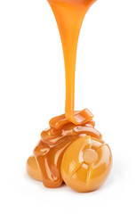 Delicious caramel sauce pouring on white background