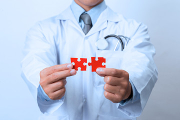 Doctor connecting jigsaw pieces of a head