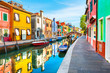 Colorful houses with reflections on the canal in Burano island, Venice, Italy. Famous travel destination