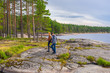 © Tatyana_Andreyeva - Middle aged man and young lady walking on northern lake shore in summer day. Tourists against picturesque landscape. Travelling and discovering distant places of Earth. Onega lake, Karelia, Russia
