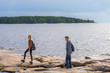 © Tatyana_Andreyeva - Middle aged man and young lady walking on northern lake shore in summer day. Tourists against picturesque landscape. Travelling and discovering distant places of Earth. Onega lake, Karelia, Russia