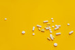 Tablets, pills and other medicine scattered on the orange background. Treatment of illness, malaise. 