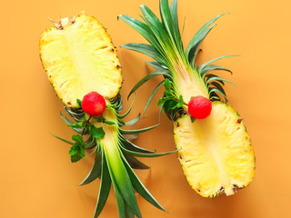 Wall Mural - Pineapple fruit cut in half on orange background in top view for tropical summer fruit concept.